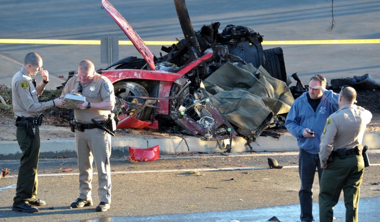 Image: Sheriff deputies work near the wreckage of a Porsche