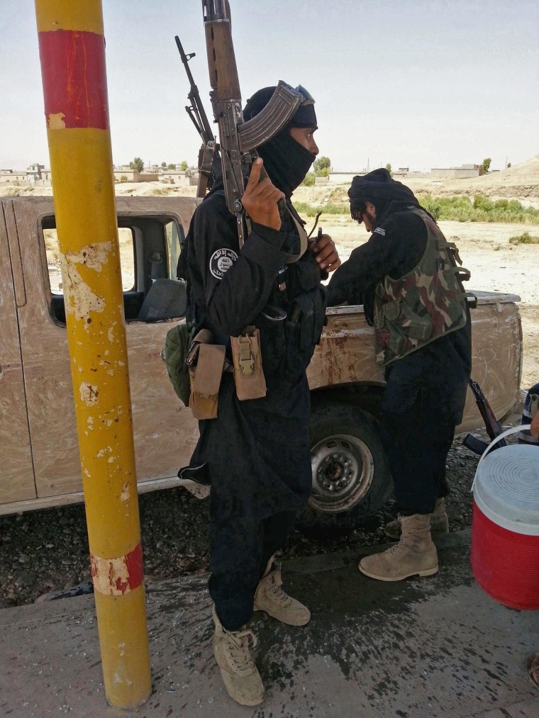 Image: Islamic State militants stand guard after controlling a checkpoint in Khazer at the border area of the Kurdish semi-autonomous region