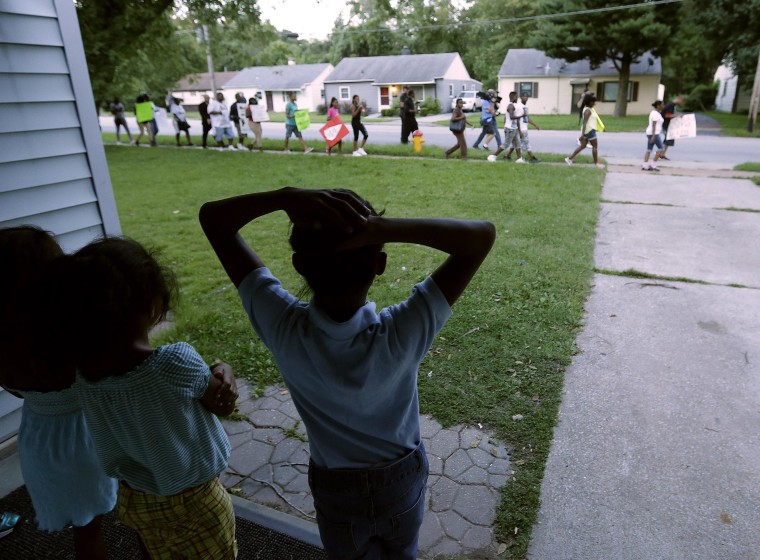 Image: Children watch from their home as people march about a mile to the police station to protest the shooting of Michael Brown on Aug. 20, in Ferguson, Mo