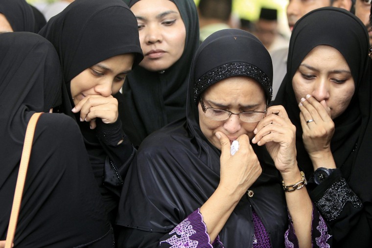 Image: Family members of Nur Shazana, a Malaysia Airlines crew member who was among the victims onboard Flight MH17, cry during a burial ceremony