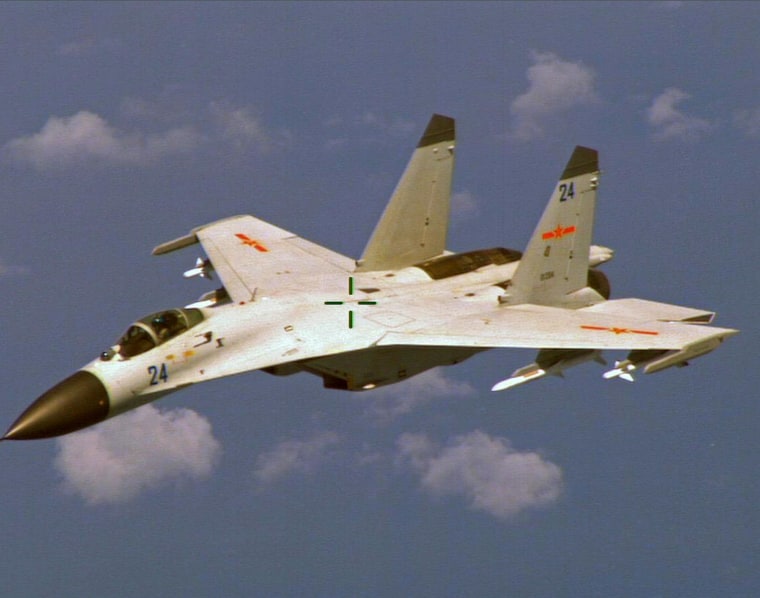 Image: A Chinese J-11 fighter jet is seen flying near a U.S. Navy P-8 Poseidon east of China's Hainan Island