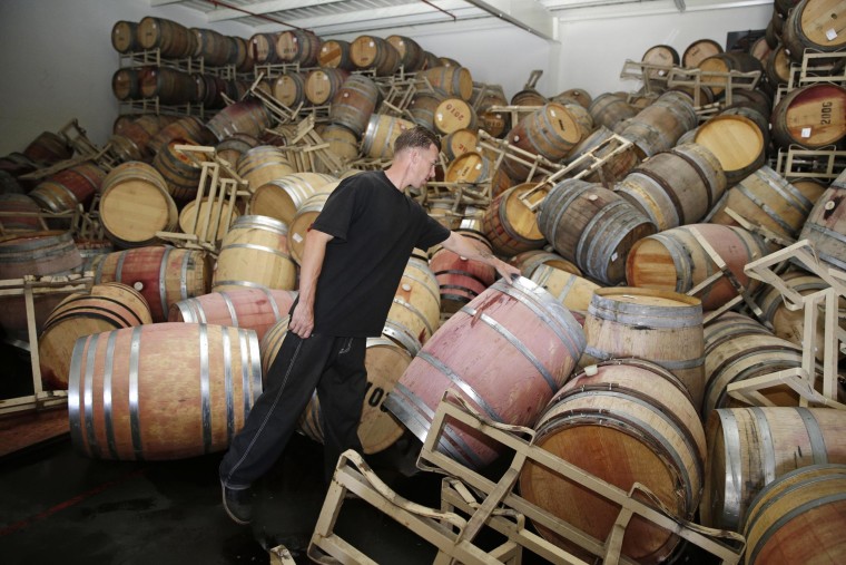 Image: Cellar worker Daniel Nelson looks over toppled barrels