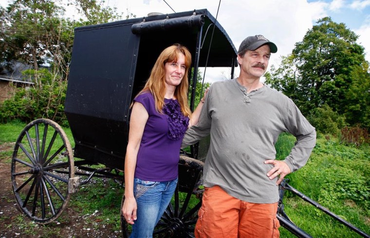 Image: Jeffrey M. and Pamela L. Stinson pose for a portrait outside an Amish buggy