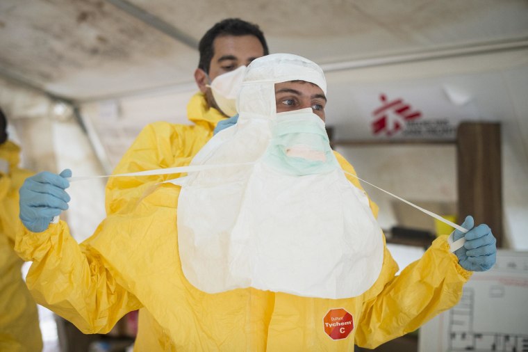Image: A Doctors Without Borders logistician puts on protective clothing at an Ebola treatment center in Guinea