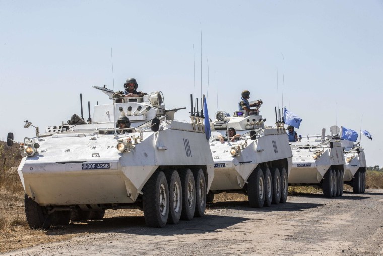Irish members of the United Nations Disengagement Observer Force (UNDOF) sit on their armored vehicles in the Israeli-annexed Golan Heights as they wait to cross into Syrian-controlled territory on Thursday.