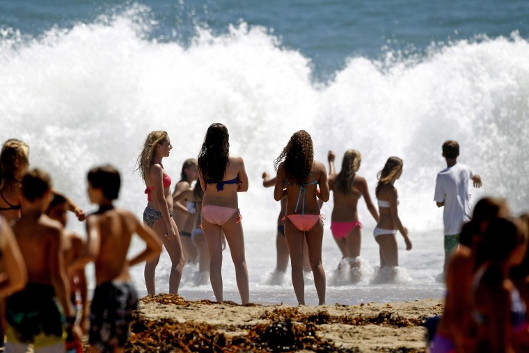 Image: Beachgoers watch large waves crash on the shore at Seal Beach, Calif., on Aug. 26. 
