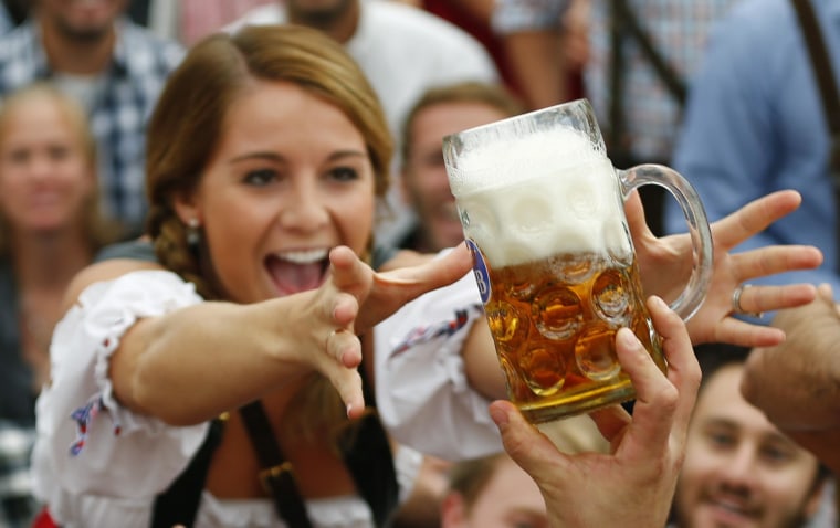 Image: A visitor reaches for a mug of beer during Oktoberfest's opening ceremony on Sept. 21, 2013