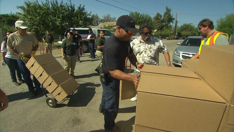 Image: Volunteers and county officials from Tulare County deliver water in East Porterville, CA.