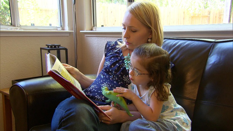 Image: Megan reads a book to her daughter, Isobel, 3, who was diagnosed with autism as a baby