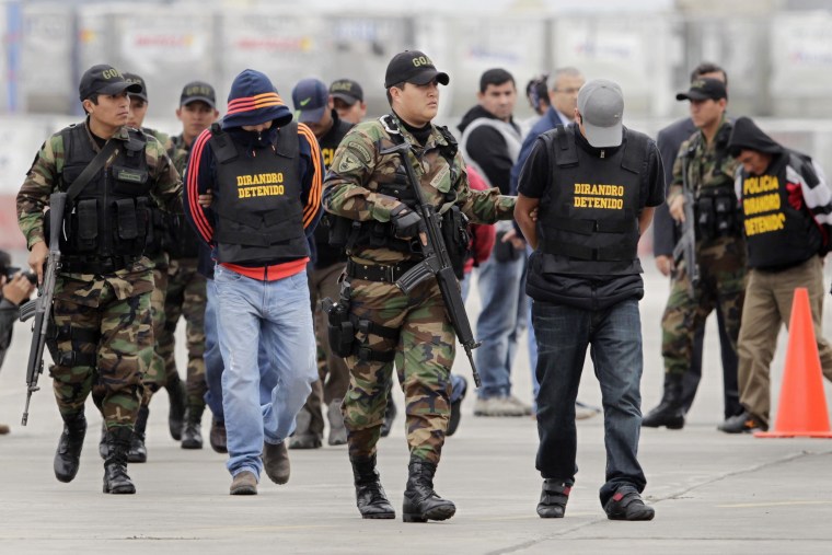 Image: Mexicans suspected of trying to smuggle 7.6 tonnes of cocaine to Europe are escorted by police officers after their arrival to the police airport in Lima