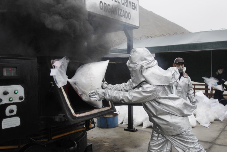 Image: Anti-narcotics officers burn bags of the cocaine seized last week near Trujillo at a special operation police headquarters, in Lima