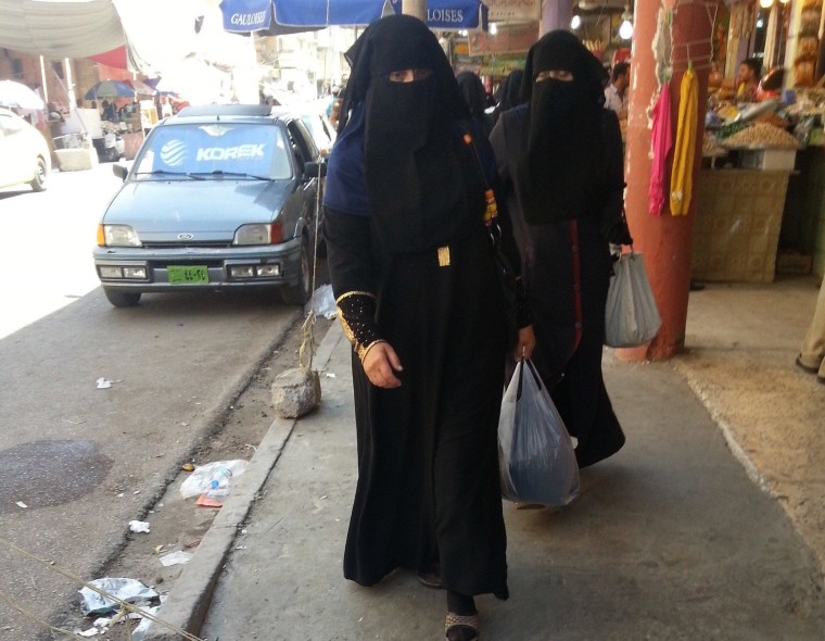 Image: Veiled Iraqi women walk along a street in the city of Mosul