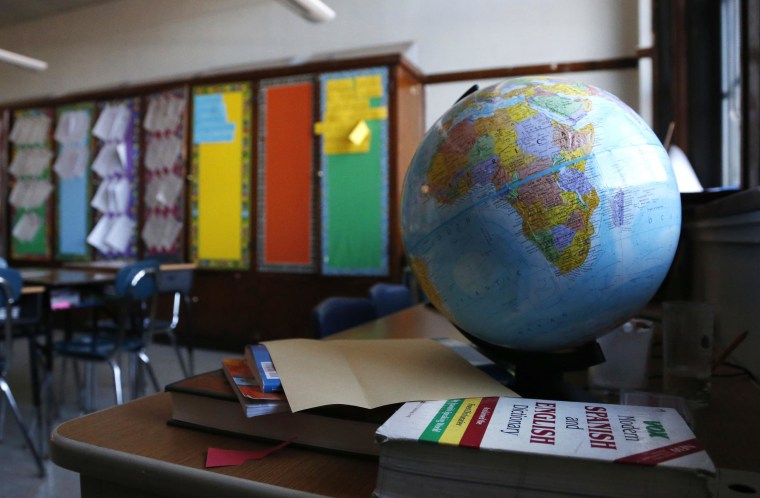 Image: A globe sits on a desk in a classroom.