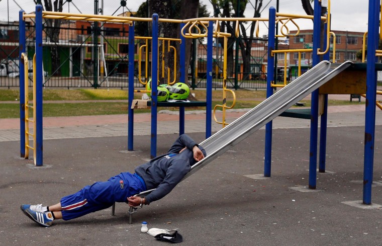 A detainee rests, handcuffed to a slide, at a children’s playground in a public park in Bogota, Colombia, Thursday, Sept. 11, 2014. Due to overcrowding at a detention center located across the street, the park has been converted into makeshift holding are