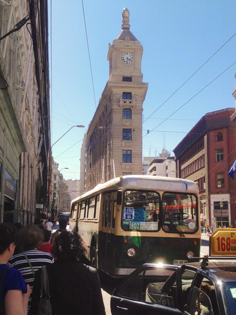 Image: A trolley bus and the Turri clock tower behind it in the financial district of Valparaiso, Chile.