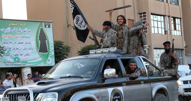 Image: Members of the Islamic State militant group parade in a street in the Syrian city of Raqqa