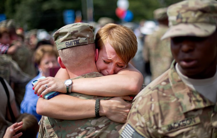 Image: Bailey Smith, right, embraces her husband Capt. Jared Smith as he returns from a deployment to Afghanistan with the Georgia National Guard's 48th Infantry Brigade Combat Team