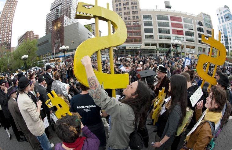 A young man holds up a dollar sign during an Occupy Wall Street rally against the high cost of college tuition April 25, 2012 in New York.