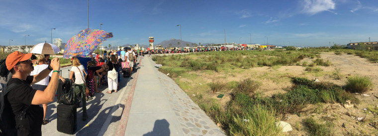 A line of tourists waiting to get a flight out of Cabo San Lucas.