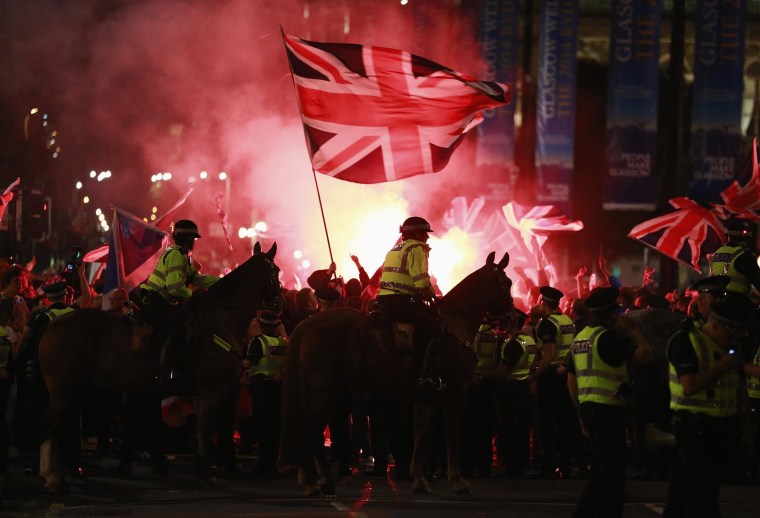 Image: Flares are let off as police stand guard while pro-union protestors clash with pro-independence protestors during a demonstration at George Square in Glasgow