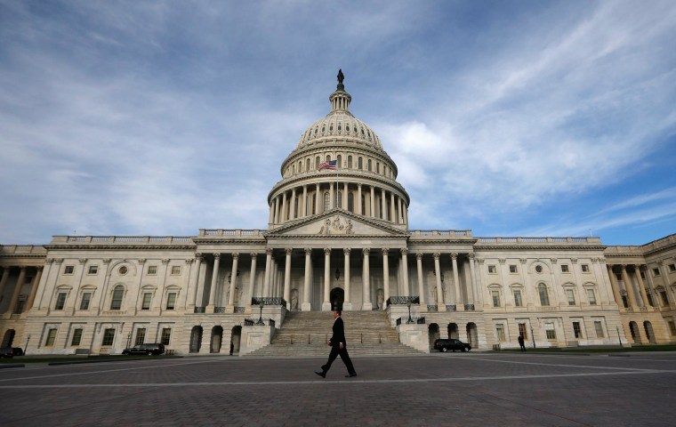 Image: A lone worker passes by the U.S. Capitol building in Washington