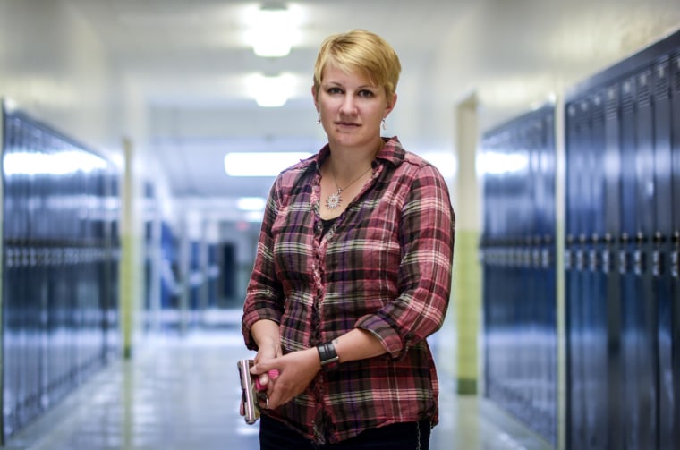 IMAGE: Kasey Hansen poses with her handgun in the hallway outside one of her classrooms at Valley Junior High School 