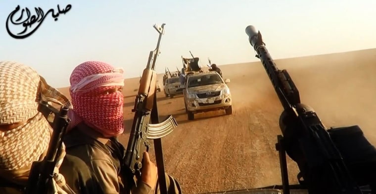 Image: ISIL militants driving in vehicles near the central Iraqi city of Tikrit