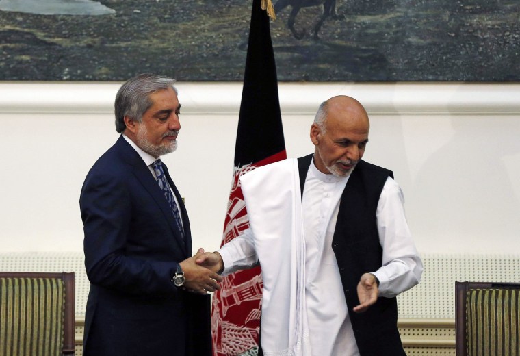 Image: Afghan rival presidential candidates Abdullah and Ghani shake hands after exchanging signed agreements for the country's unity government in Kabul