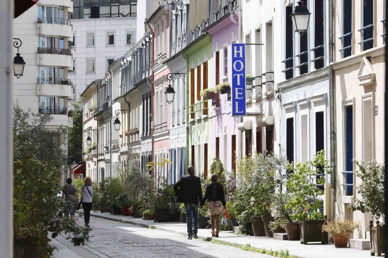 Image: A view shows people walking rue Cremieux, a street lined with colorful, terraced homes, and the hotel "L'Hotel Particulier" located in the 12th district of Paris