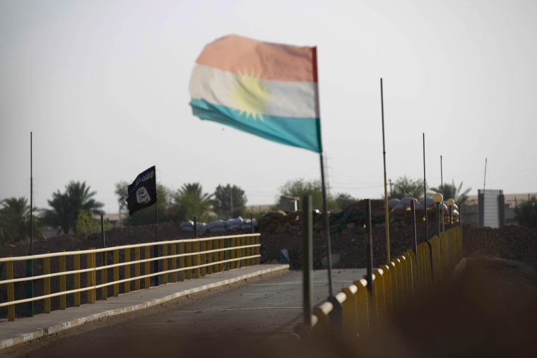 Image: A Kurdish and an ISIS flag on a bridge at the village of “Mula Abdula” in Kirkuk, Iraq