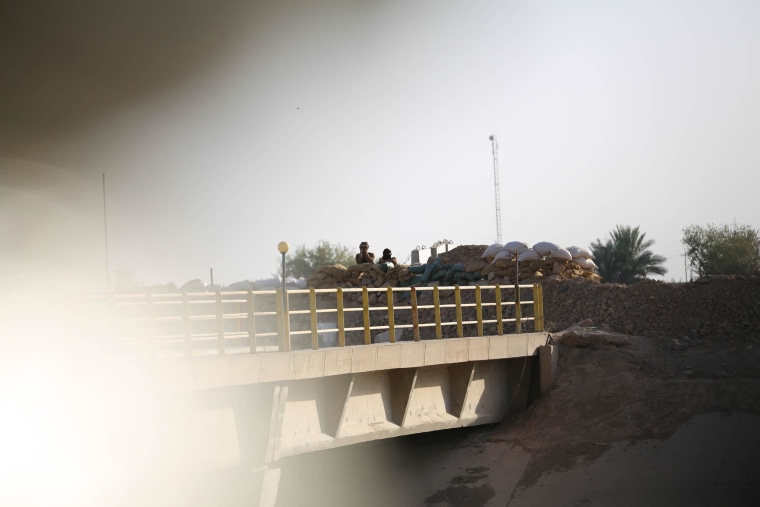 Image: A Kurdish and an ISIS flag on a bridge at the village of “Mula Abdula” in Kirkuk, Iraq