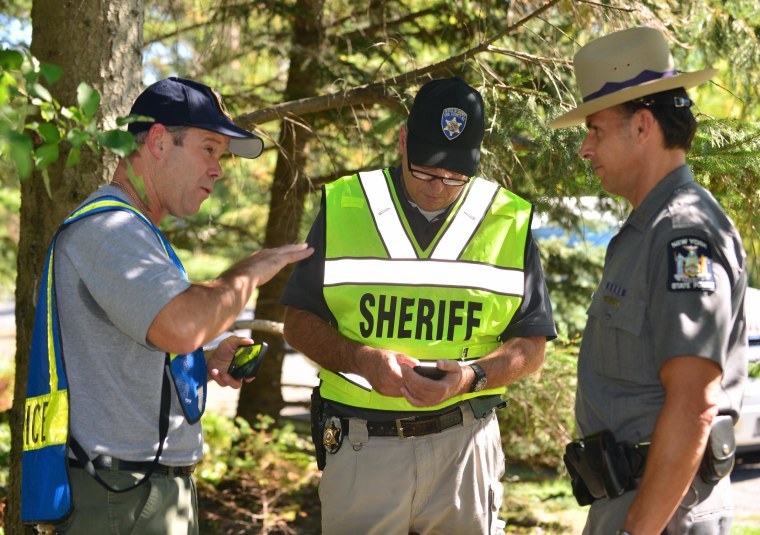 Image: Lancaster Police Chief Gerald Gill, left,  Erie County Sheriffs' Capt. Gregory Savage, center, and New York State Troopers Capt. Steve Graap collect information after a mid-air collision involving two planes in Lancaster, N.Y.,