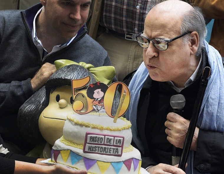 Image: Cartoonist Joaquín Salvador Lavado known as Quino blows the candle next to Mafalda