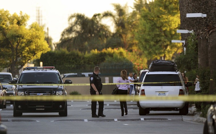 Image: A police officer and residents are seen at the condo where Mayor Daniel Crespo was shot in Bell Gardens, California