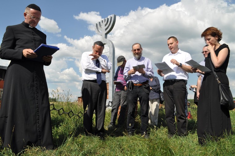Priests and rabbis pray at the memorial at Wasosz, Poland.
