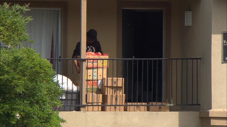 Image: Relatives of Ebola patient Thomas Duncan pick up foods delivered to their apartment in Dallas, They've been confined while officials assess their risk of infection