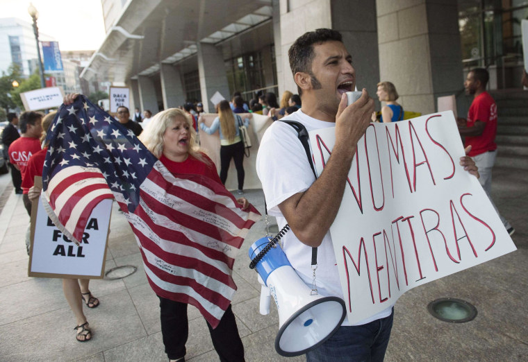 Image: Demonstrators with the groups National Day Laborer Organizing Network, Workers United of Washington and the #Not1More Campaign, protest an increase in deportations