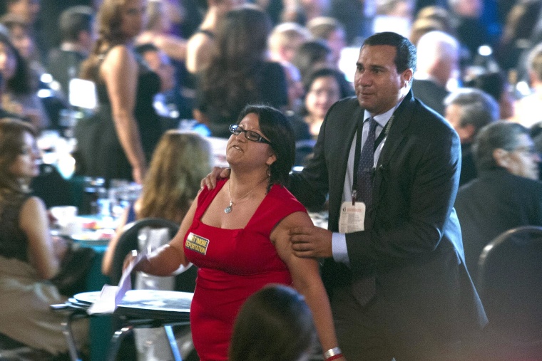 Image: A woman who was shouting at President Barack Obama as he addressed the Congressional Hispanic Caucus Institute's 37th annual awards gala is removed