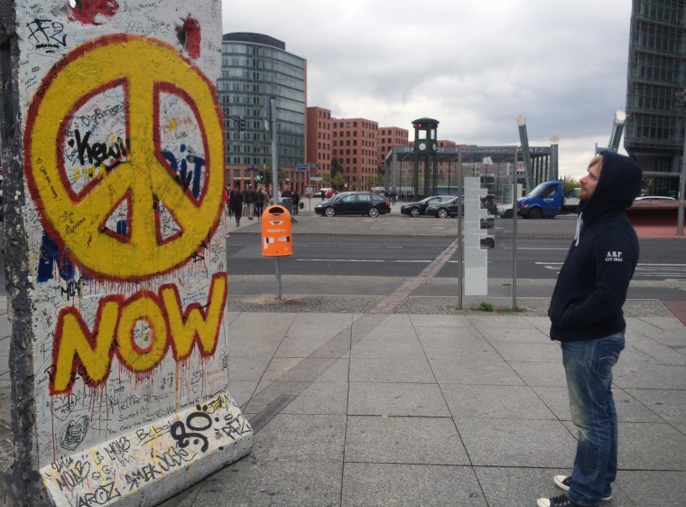 Image: A young man looking at a slab of the former Berlin Wall at Potsdamer Platz