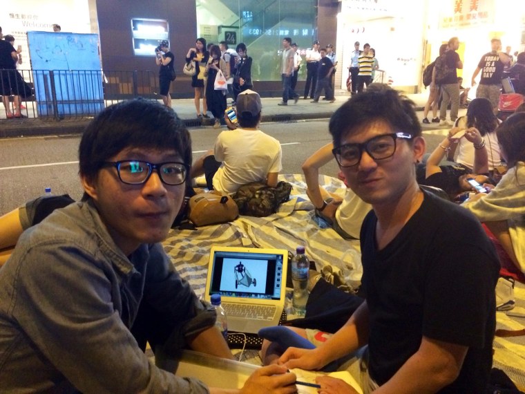 Sophomores Peter Chung, left, and Hugo Chan, both 21, work on a project for their Visual Communications course while taking part in the protests in Hong Kong.