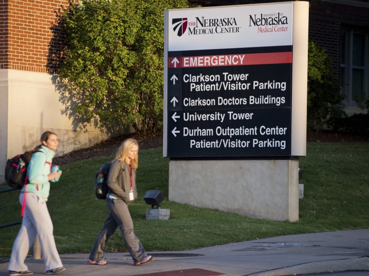 Pedestrians walk by the intersection to the Nebraska Medical Center in Omaha where a freelance cameraman who is the fifth American to contract Ebola in West Africa, arrived in the United States for treatment.