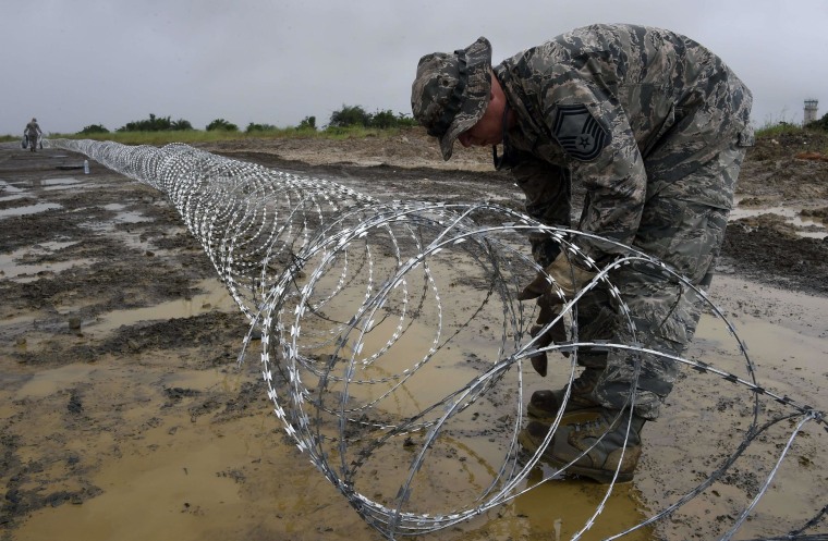 Image: Air Force personnel lay out barbed wire around the position for an Ebola treatment center in Monrovia, Liberia