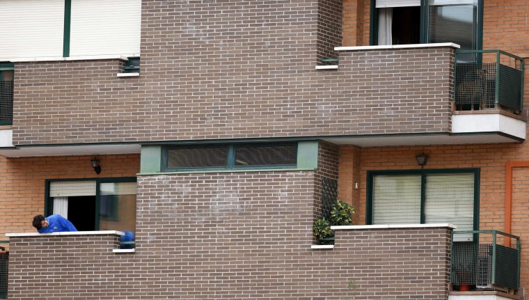 Image: Neighbor tries to get a glimpse of Excalibur, the dog of the Spanish nurse who contracted Ebola, on her apartment's balcony in Alcorcon, outside Madrid