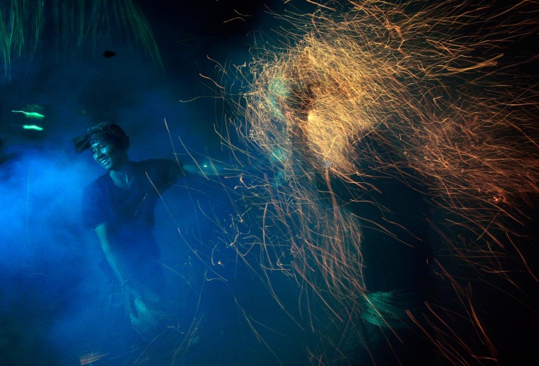 Image: Balinese men lash burning coconut husks during "Mesabatan Api," in Bali on Wednesday.