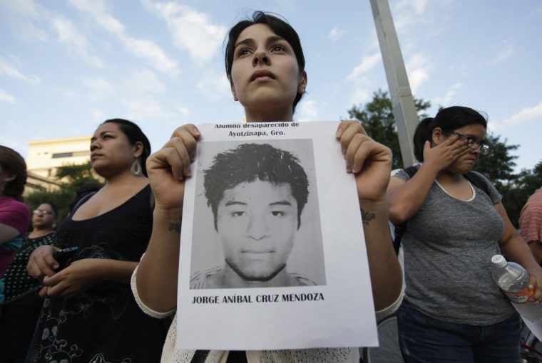 Image: A woman holds a photograph of a missing student during a march in support of the Ayotzinapa Teacher Training College missing students, in Monterrey