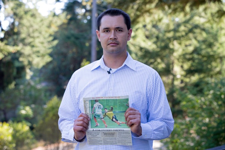 Casey Sullivan holds a photograph taken before he was diagnosed with stage 4 Hodgkin lymphoma. Sullivan, a former goalkeeper, wonders whether his time spent on crumb rubber artificial turf exposed him to harmful chemicals.