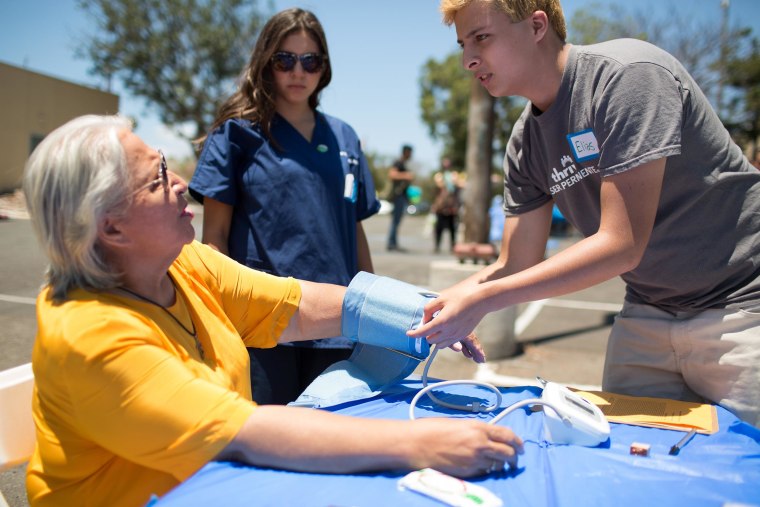 Image: Medical Pathways graduate Elias Preciado checks a patient's blood pressure