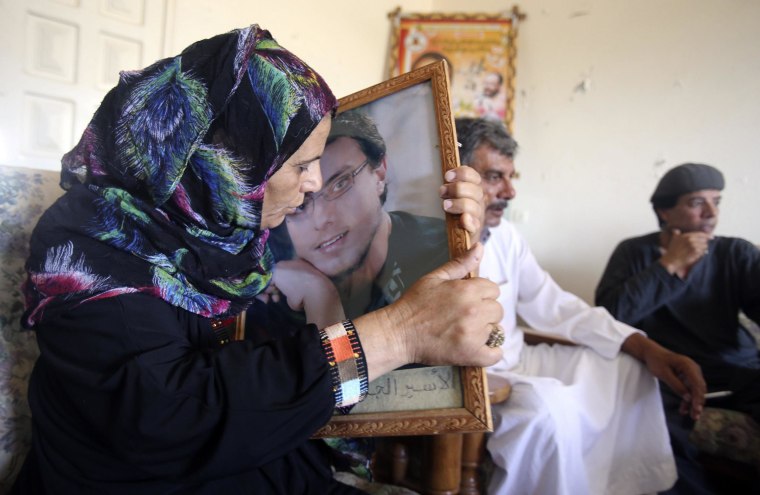 Image: Ahmad Asfour's mother kisses his picture at her house in Khan Younis in the southern Gaza Strip