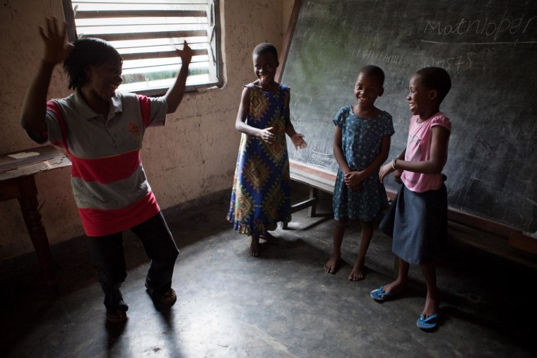 A psychologist working for the NGO Amici Di Bambini (Children's Friends) gestures towards children who have been rejected by their families after being accused of witchcraft