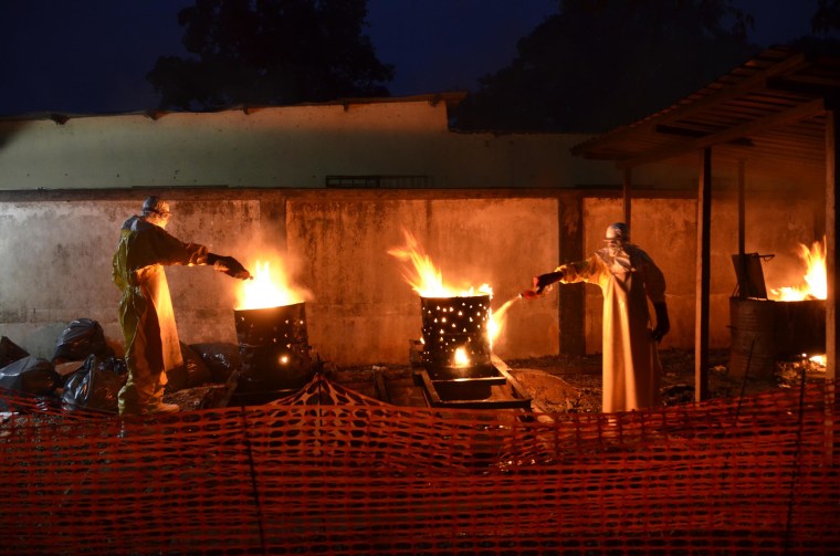 Doctors Without Borders (MSF) staff incinerate waste material at the organization's Ebola treatment center in Conakry, Guinea, Oct. 9, 2014. 